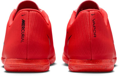 Dve červené topánky Nike Mercurial Vapor s nápismi na päte a podrážkou Non-Marking. Dve červené topánky Nike Mercurial Vapor s nápismi na päte a podrážkou Non-Marking.