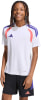Junge im weißen Adidas T-Shirt mit lila und rosa Details und schwarzer Hose.