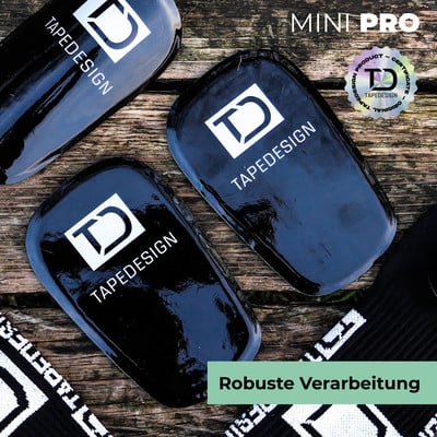 Schwarze Schoner mit TD-Logo und TAPEDESIGN-Schriftzug auf Holzuntergrund.