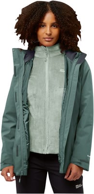 Frau in grüner Jacke mit Fleeceweste und schwarzer Hose. Frau in grüner Jacke mit Fleeceweste und schwarzer Hose.