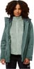 Frau in grüner Jacke mit Fleeceweste und schwarzer Hose.