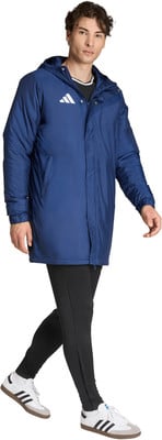 Ein Mann in dunkelblauer Kapuzenjacke und schwarzen Leggings, weiße Sneaker.