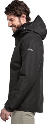 Ein Mann in einer schwarzen wasserdichten Jacke mit Kapuze und heller Hose. Ein Mann in einer schwarzen wasserdichten Jacke mit Kapuze und heller Hose.