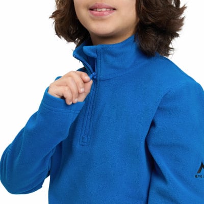 Ein Kind schließt einen blauen Fleece-Pullover mit Reißverschluss.