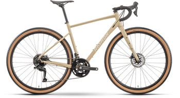 Ein sandfarbenes RAYMON Gravelbike mit braunen Reifen und schwarzen Komponenten.