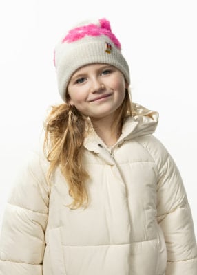 Ein junges Mädchen mit blonden Haaren und einem Lächeln trägt eine Winterjacke und eine Mütze. Ein junges Mädchen mit blonden Haaren und einem Lächeln trägt eine Winterjacke und eine Mütze.