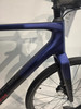 Detail des Rahmens eines blauen Fahrrads mit Gabel und Vorderrad.