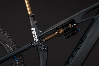 Detail des Hinterbaus eines Mountainbikes mit Fox-Dämpfer und Cube-Logo.