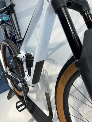 Detail eines weißen Mountainbikes mit Dämpfer und braunen Reifen. Detail eines weißen Mountainbikes mit Dämpfer und braunen Reifen.
