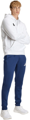 Junger Mann im weißen Hoodie und dunkelblauer Jogginghose. Junger Mann im weißen Hoodie und dunkelblauer Jogginghose.