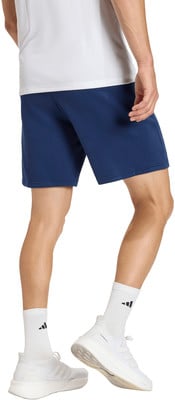 Ein Mann in dunkelblauen Shorts und weißen Socken mit Turnschuhen.