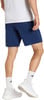 Ein Mann in dunkelblauen Shorts und weißen Socken mit Turnschuhen.