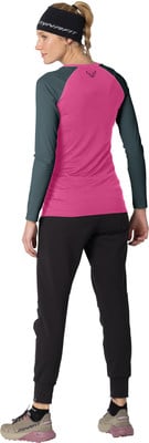 Frau in einem rosa Langarmshirt, schwarzer Hose und Mütze. Frau in einem rosa Langarmshirt, schwarzer Hose und Mütze.