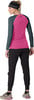 Frau in einem rosa Langarmshirt, schwarzer Hose und Mütze.