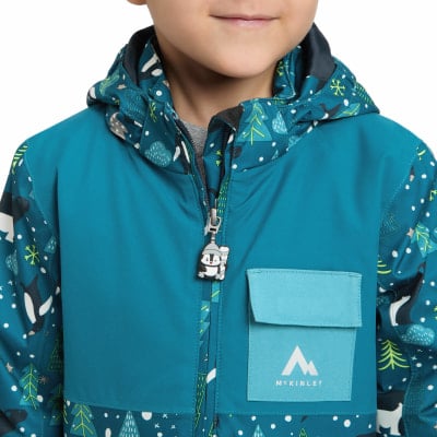 Blaue Kinderjacke mit Wintermotiv-Aufdruck und Pinguin am Reißverschluss.
