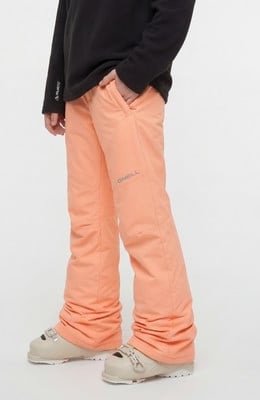 Mädchen in orangefarbener Skihose mit O'Neill-Logo und Skischuhen.