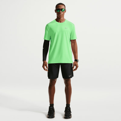 Ein Mann in einem grünen Hemd und schwarzen Shorts mit Nike-Logo.