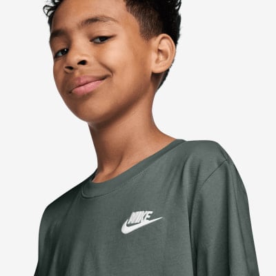 Junge in dunkelgrünem Nike T-Shirt mit Logo. Junge in dunkelgrünem Nike T-Shirt mit Logo.