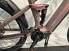 Detail des rosafarbenen E-Bikes mit RockShox-Dämpfer und Bosch-Antrieb.