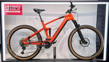 Ein orangefarbenes Cube Mountainbike mit schwarzen Details auf einem Ständer.