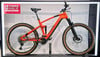 Ein orangefarbenes Cube Mountainbike mit schwarzen Details auf einem Ständer.