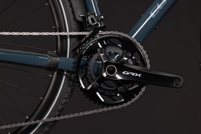 Detailaufnahme von Fahrradkurbeln und Kette mit GRX-Logo. Detailaufnahme von Fahrradkurbeln und Kette mit GRX-Logo.