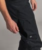 Eine männliche Hand greift in die offene Seitentasche einer schwarzen Hose.