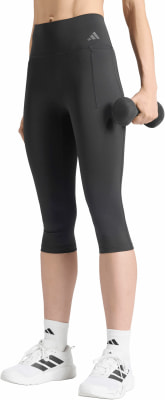 Eine Frau in schwarzen Leggings und weißen Turnschuhen hält eine Hantel. Eine Frau in schwarzen Leggings und weißen Turnschuhen hält eine Hantel.