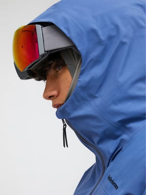 Ein Mann in einer blauen Jacke mit Skibrille auf dem Kopf. Ein Mann in einer blauen Jacke mit Skibrille auf dem Kopf.