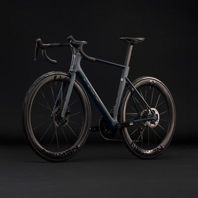 Elegantes dunkelblaues Rennrad mit Carbonfelgen vor schwarzem Hintergrund.