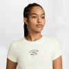 Eine Frau in einem weißen T-Shirt mit Nike-Logo und dem Aufdruck Athletics.