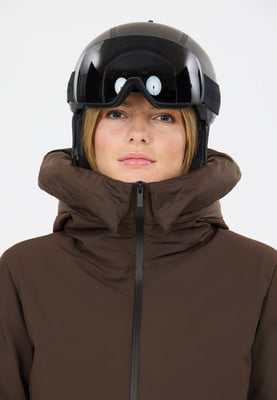 Frau in einem Skischutzhelm und einer Kapuzenjacke vor weißem Hintergrund. Frau in einem Skischutzhelm und einer Kapuzenjacke vor weißem Hintergrund.