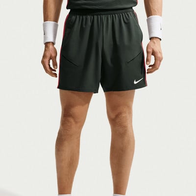 Ein Mann in dunklen Shorts mit rotem Streifen und weißen Schweißbändern. Ein Mann in dunklen Shorts mit rotem Streifen und weißen Schweißbändern.