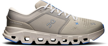 Beige Laufschuhe von On Running mit blauen Akzenten und weißen Schnürsenkeln.