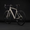 Ein graues CUBE Gravelbike mit schwarzen Rädern und Details auf dunklem Hintergrund.