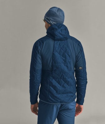Mann von hinten in blauer gesteppter Kapuzenjacke und Mütze. Mann von hinten in blauer gesteppter Kapuzenjacke und Mütze.
