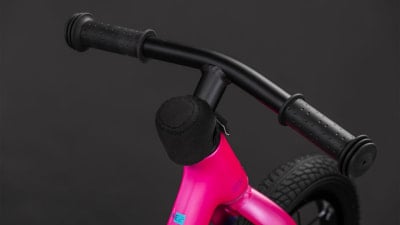Ein pinkes Kinderfahrrad mit schwarzem Lenker und Schaumstoffpolster. Ein pinkes Kinderfahrrad mit schwarzem Lenker und Schaumstoffpolster.