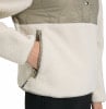 Detail einer Hand in der Tasche einer Fleecejacke mit gestepptem Oberteil.