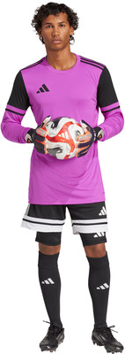 Ein Fußballtorwart im pinken Trikot mit schwarzen Ärmeln hält einen Ball.