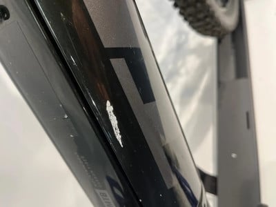 Auf dem schwarzen Fahrradrahmen befinden sich weiße Abriebspuren und Kratzer. Auf dem schwarzen Fahrradrahmen befinden sich weiße Abriebspuren und Kratzer.