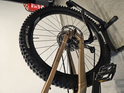 Ein aufgehängtes Mountainbike auf einem Ständer mit Detailansicht des Reifens. Ein aufgehängtes Mountainbike auf einem Ständer mit Detailansicht des Reifens.