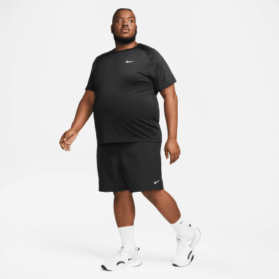 Ein Mann in einem schwarzen Nike-T-Shirt und Shorts mit weißen Turnschuhen.