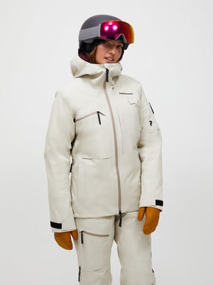 Skifahrerin in weißer Jacke und Hose, mit Helm und Brille. Skifahrerin in weißer Jacke und Hose, mit Helm und Brille.