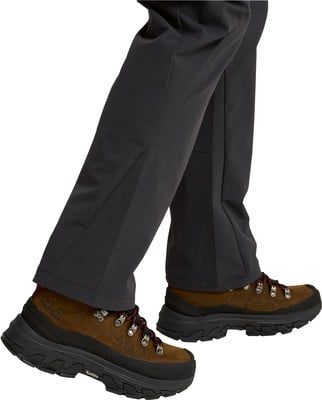 Braune Wanderschuhe mit Schnürung und schwarzer Sohle, getragen mit dunklen Hosen. Braune Wanderschuhe mit Schnürung und schwarzer Sohle, getragen mit dunklen Hosen.