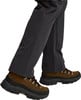 Braune Wanderschuhe mit Schnürung und schwarzer Sohle, getragen mit dunklen Hosen.