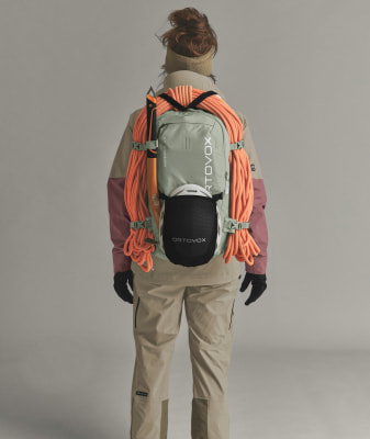 Rückansicht einer Person mit Kletterausrüstung auf dem Rücken. Rückansicht einer Person mit Kletterausrüstung auf dem Rücken.