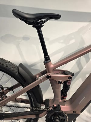 Das Heck eines rosafarbenen E-Bikes mit RockShox-Dämpfer und Schutzblech. Das Heck eines rosafarbenen E-Bikes mit RockShox-Dämpfer und Schutzblech.