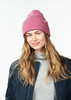 Frau in einer rosa Mütze und dunkelblauem Jacke mit Rollkragen.