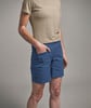 Eine Frau in einem beigen T-Shirt und blauen Shorts mit Vitiligo.