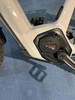 Detail eines E-Bikes mit Bosch Performance Line CX Motor und Kurbeln auf blauem Teppich.